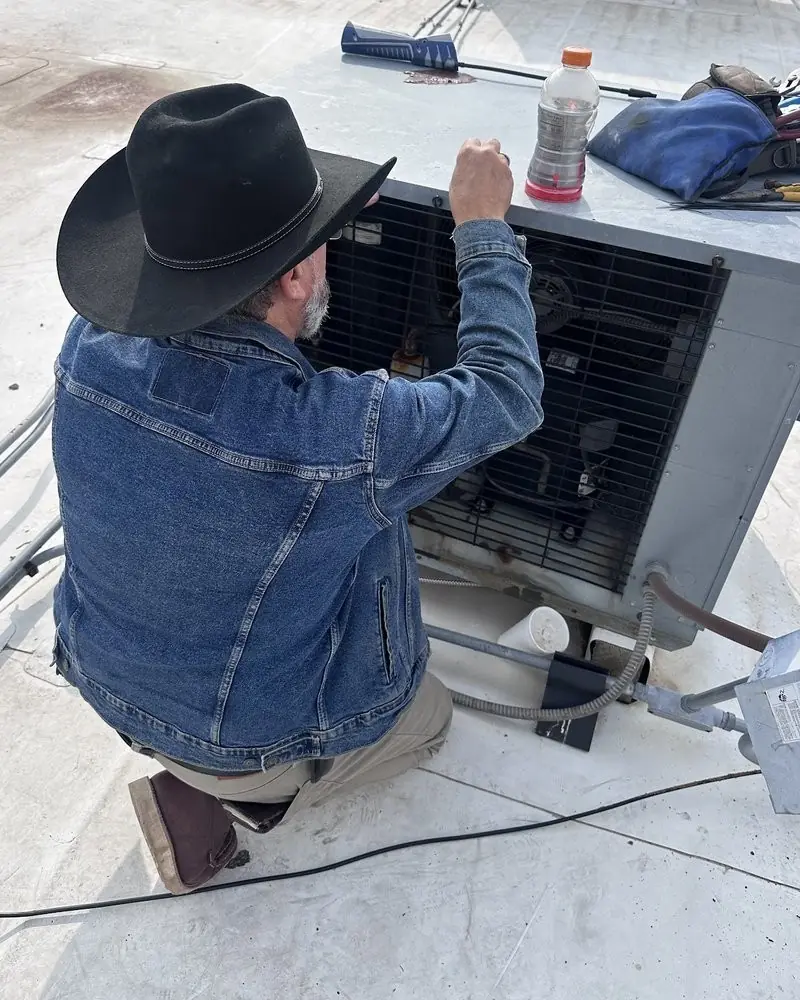 Clay Kerr, founder of Texian Cold, performing rooftop HVAC service in Central Texas