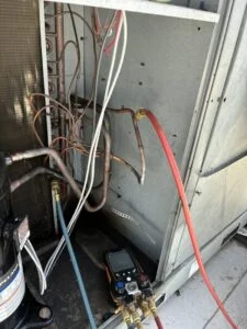Manifold gauges connected to a rooftop commercial chiller during service in Waco, TX