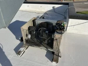 Rooftop walk-in cooler condensing unit with its cover off during a service call at a Waco, TX restaurant